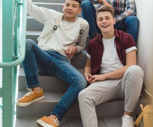 teenage-schoolboys-sitting-on-stairs-at-school-and-L4MN3UL.jpg